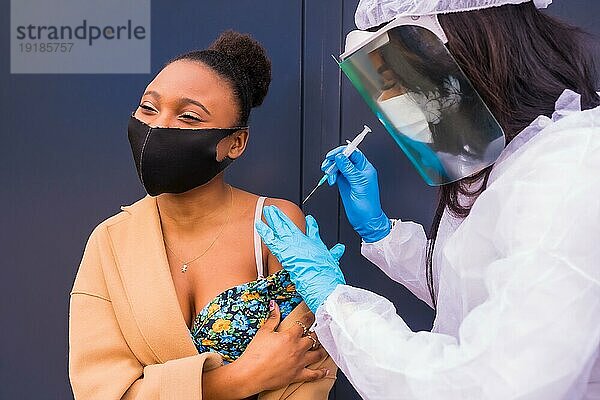 Junges Mädchen  das von einer Ärztin mit dem Coronavirusimpfstoff geimpft wird  Antikörper  immunisiert die Bevölkerung  gefährdete Personen  neue Normalität  Covid19