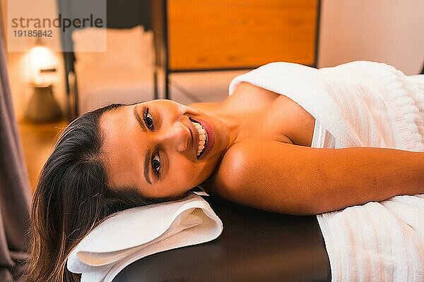 Massage zu Hause  Durchführung einer Massage zu Hause zufriedener Kunde. Mit einer Gesichtsmaske bei der Coronaviruspandemie