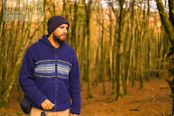 Lifestyle  ein junger Mann in einem blauen Wollpullover und einem Hut  der den Wald im Herbst genießt. Artikutza Wald in San Sebastián  Gipuzkoa  Baskenland. Spanien
