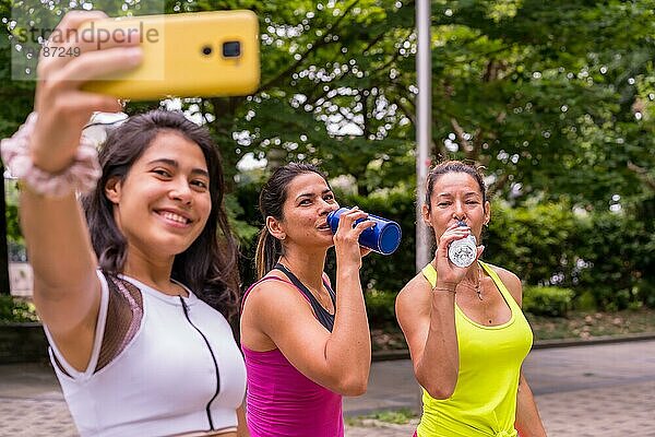 Latina Mädchen macht Sport in einem Park in der Stadt  Lebensstil ein gesundes Leben  ein Selfie mit dem Telefon nach dem Training