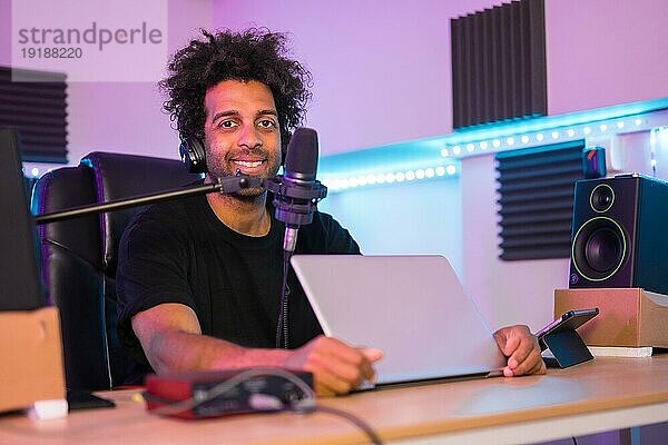 Porträt eines Podcaster in einem Musikstudio mit elektronischen Hilfsmitteln für die Ausstrahlung