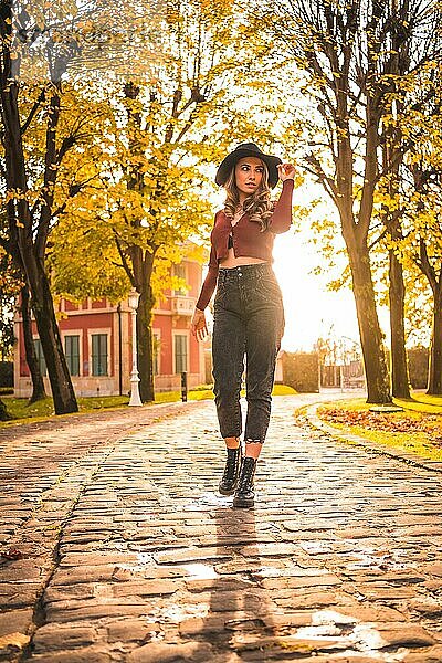 Kaukasisches Mädchen mit Hut in einem Wald  das im Herbst spazieren geht