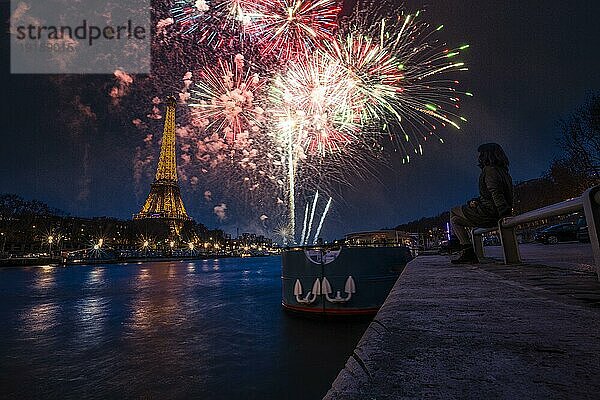 Eine junge Frau in der Stadt der Liebe genießt ein Feuerwerk am Ufer der Seine in Paris. Frankreich
