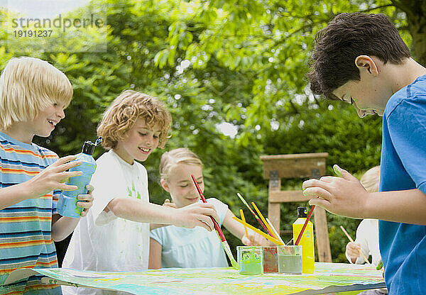 Kinder malen und lächeln im Garten