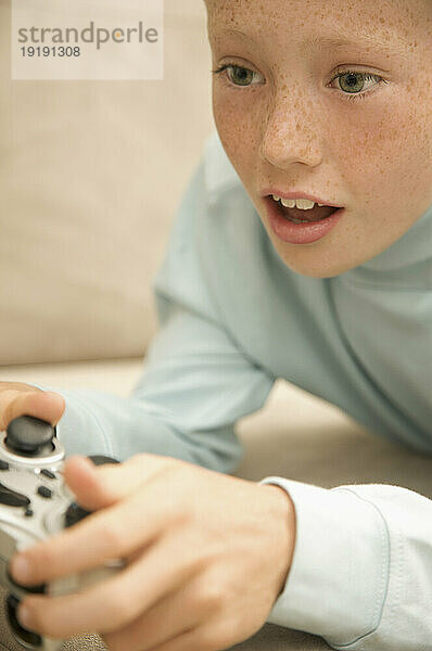 Nahaufnahme eines kleinen Jungen  der spielt und ein Videospiel steuert