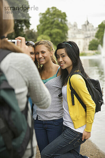 Rückansicht einer Frau  die drei Mädchen im Teenageralter fotografiert