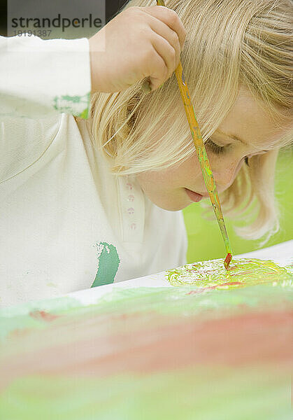 Nahaufnahme eines jungen blonden Mädchens beim Malen
