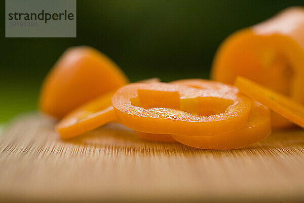 In Scheiben geschnittene orangefarbene Paprika auf einem Schneidebrett