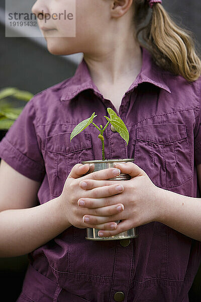 Nahaufnahme eines jungen Mädchens  das eine Pflanze hält