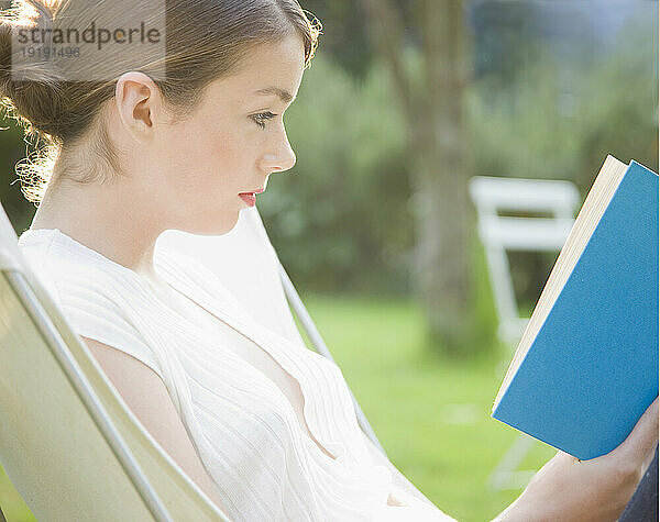 Teenager-Mädchen sitzt und liest ein Buch