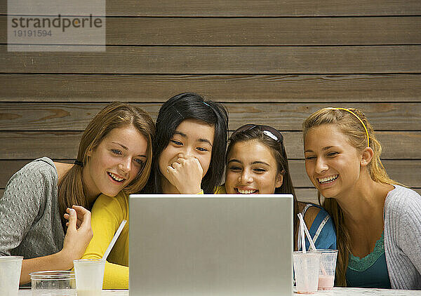 Teenager-Mädchen benutzen Laptop-Computer und lachen