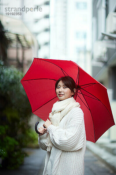 Japanerin mit Regenschirm draußen