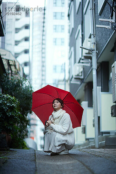 Japanerin mit Regenschirm draußen