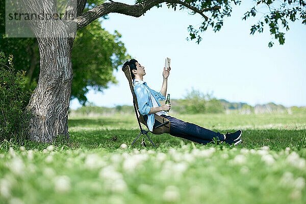 Japanischer Mann entspannt sich im Stadtpark