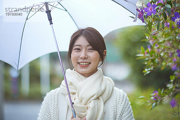 Japanerin mit Regenschirm draußen