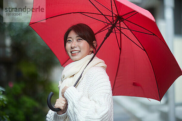Japanerin mit Regenschirm draußen