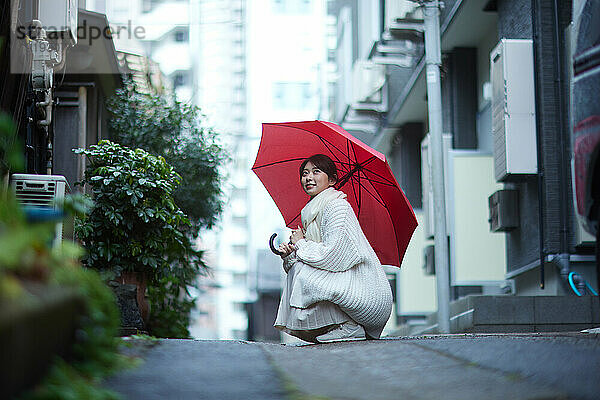 Japanerin mit Regenschirm draußen