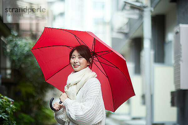 Japanerin mit Regenschirm draußen