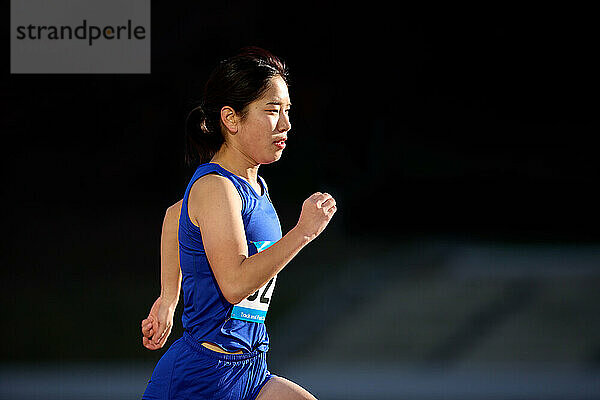 Japanese athlete running on track