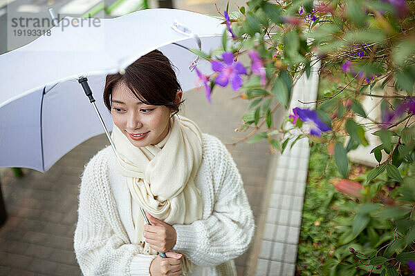 Japanerin mit Regenschirm draußen