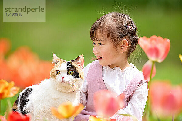 Japanisches Kind mit süßer Katze im Park