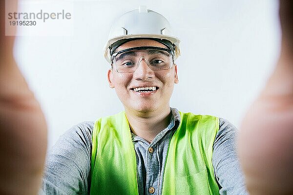 Lächelnder männlicher Ingenieur  der ein Selfie macht und in die Kamera schaut. Fröhlich Bauherr Ingenieur  der ein Selfie isoliert  Ingenieur