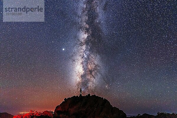 Silhouette eines jungen Mannes unter dem Sternenhimmel mit Blick auf den Lactea Weg der Caldera de Taburiente in der Nähe des Roque de los Muchahos auf der Insel La Palma  Kanarische Inseln. Spanien  Astrofotografie