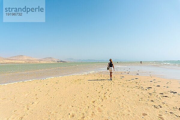 Ein junger Tourist spaziert an einem Herbstmorgen am Strand von Sotavento im Süden von Fuerteventura  Kanarische Inseln. Spanien