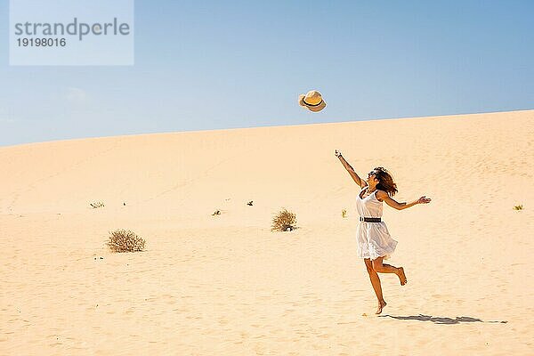 Ein Tourist  der in den Dünen des Naturparks Corralejo auf Fuerteventura  Kanarische Inseln  fröhlich seinen Hut lüftet. Spanien