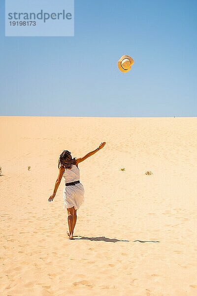 Ein Tourist  der in den Dünen des Naturparks Corralejo auf Fuerteventura  Kanarische Inseln  fröhlich seinen Hut lüftet. Spanien