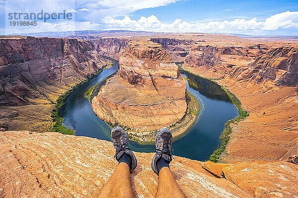 Gekreuzte Füße beim Ausruhen mit Blick auf Horseshoe Bend und den Colorado River im Hintergrund  Arizona. Vereinigte Staaten