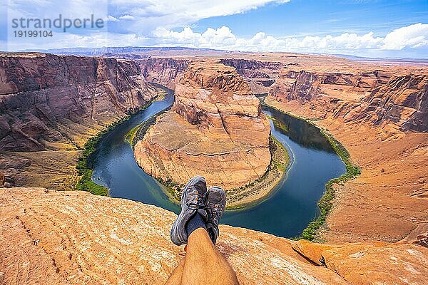 Gekreuzte Füße beim Ausruhen mit Blick auf Horseshoe Bend und den Colorado River im Hintergrund  Arizona. Vereinigte Staaten