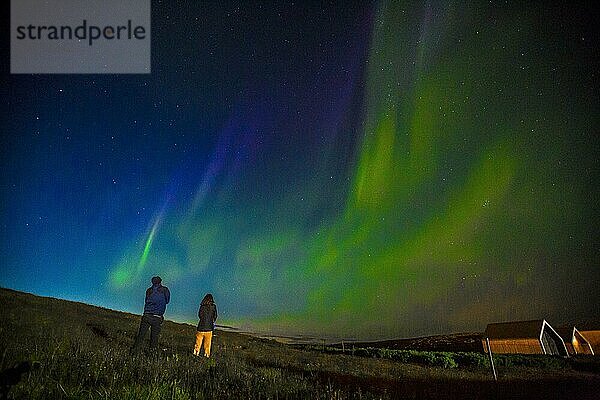 Ein Paar bei Nordlicht am Himmel auf der Halbinsel Reykjanes im Süden Islands
