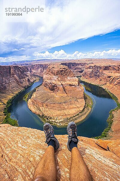 Gekreuzte Füße beim Ausruhen mit Blick auf Horseshoe Bend und den Colorado River im Hintergrund  Arizona. Vereinigte Staaten