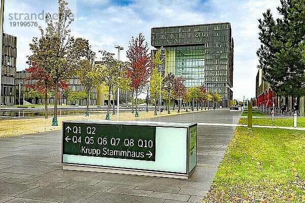 Blick auf im Hintergrund Hauptverwaltung in Form von Würfel Cube von Stahlriese Firma von Stahlproduktion Hersteller von Stahl thyssenkrupp Thyssen Krupp im Vordergrund Wegweiser und Hinweis auf Stammhaus von Familie Friedrich Krupp  Essen  Nordrhein-Westfalen  Deutschland  Europa