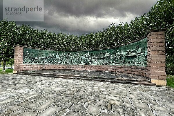 Dunkle Wolken über Tiegelgussdenkmal Denkmal für Herstellung Produktion von Stahl Tiegelstahl in Form von Panorama Halbkreis von Bildhauer Artur Hoffmann aus Jahr 1952 für Stahlarbeiter von Krupp Stahl Stahlwerke Darstellung Halbrelief von Tiegelstahlproduktion  Essen  Nordrhein-Westfalen  Deutschland  Europa