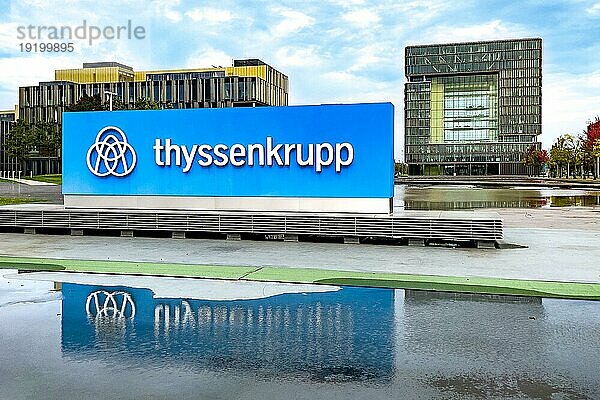 Blick auf im Hintergrund Hauptverwaltung in Form von Würfel Cube von Stahlriese Firma von Stahlproduktion Hersteller von Stahl thyssenkrupp Thyssen Krupp im Vordergrund Logo und Schriftzug  Essen  Nordrhein-Westfalen  Deutschland  Europa