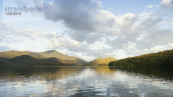 Lake Placid spiegelt den Whiteface Mountain und die Wolken wider