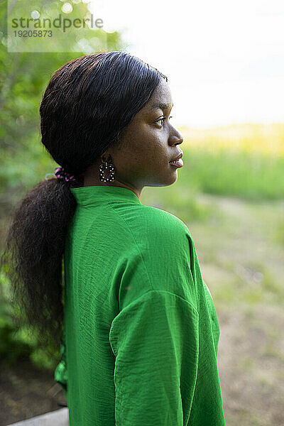 Seitenansicht einer brünetten Frau in grüner Bluse