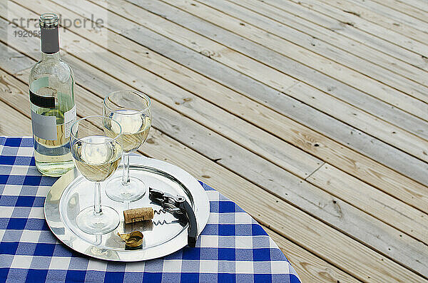 Weißweinflasche und Gläser auf dem Tisch im Freien