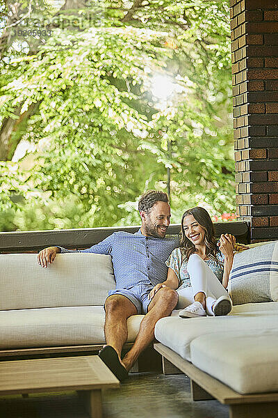 Mitte erwachsenes Paar entspannt auf dem Sofa auf der Terrasse