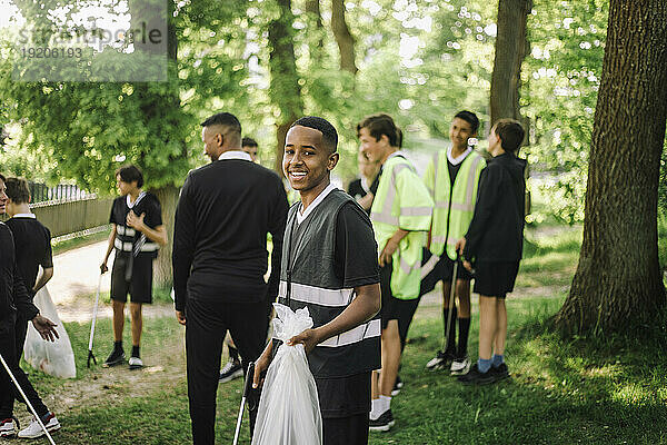 Porträt eines lächelnden Jungen mit einer Plastiktüte