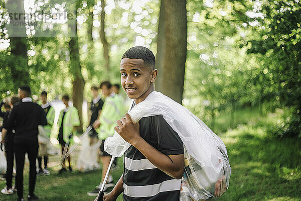 Porträt eines Jungen mit Müllsack über der Schulter