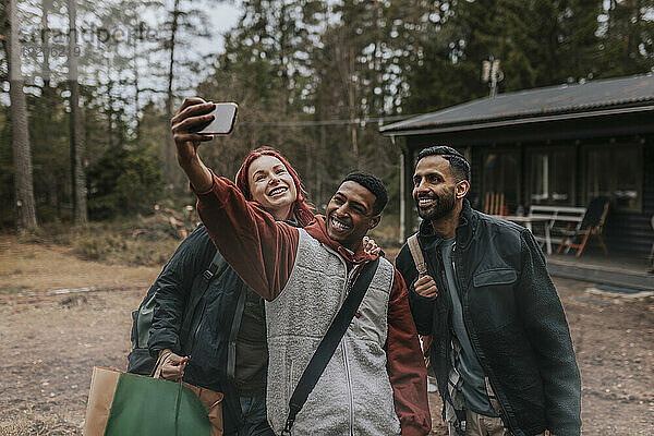 Glückliche Freunde machen Selfie mit dem Handy im Garten