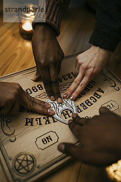 Gemischtrassige Freunde nutzen Ouija-Brett