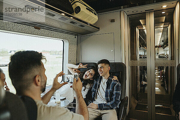 Vater fotografiert Sohn und Tochter  die Spaß im Zug haben