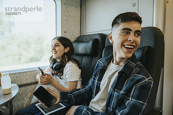 Glückliche Geschwister  die Spaß beim Reisen im Zug haben