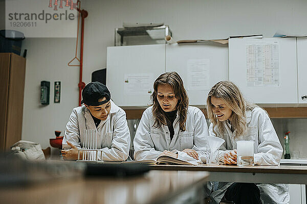 Junge gemischtrassige Studenten studieren am Schreibtisch im Labor