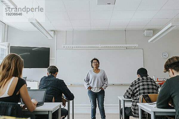 Porträt einer Lehrerin mit Schülern vor dem Whiteboard im Klassenzimmer