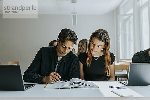 Männliche und weibliche Studenten lernen gemeinsam im Klassenzimmer